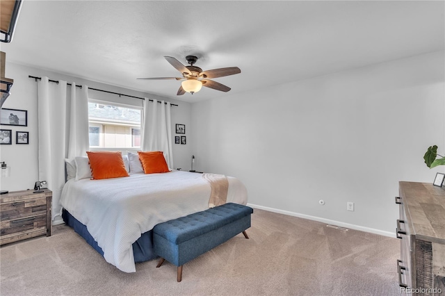 bedroom featuring baseboards, visible vents, ceiling fan, and light colored carpet