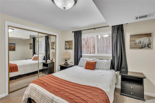 carpeted bedroom featuring visible vents, baseboards, and a closet