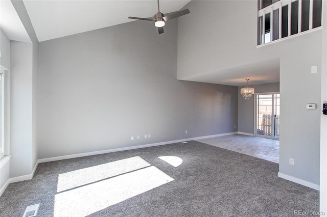 unfurnished room with ceiling fan with notable chandelier, high vaulted ceiling, and carpet