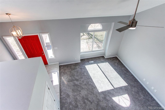 interior space featuring lofted ceiling, ceiling fan with notable chandelier, and carpet floors