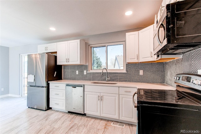 kitchen featuring backsplash, stainless steel appliances, white cabinetry, and sink