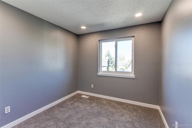 carpeted spare room with a textured ceiling