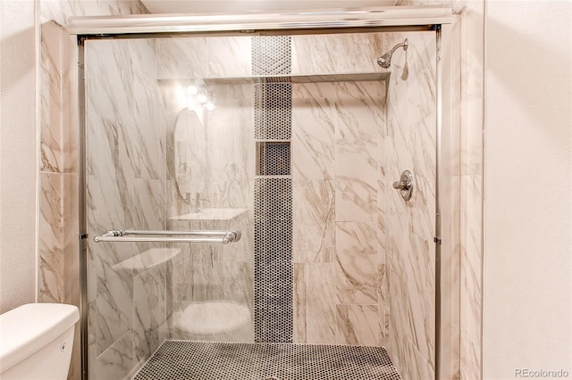 bathroom featuring toilet and an enclosed shower