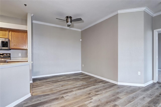 kitchen featuring appliances with stainless steel finishes, light hardwood / wood-style flooring, ceiling fan, and crown molding