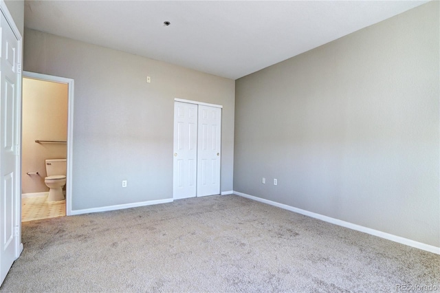 unfurnished bedroom with carpet floors, ensuite bathroom, and a closet