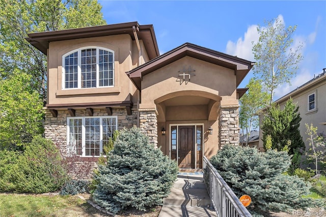 view of exterior entry with stucco siding and stone siding