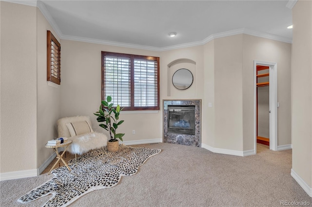 sitting room featuring baseboards, ornamental molding, carpet, and a high end fireplace