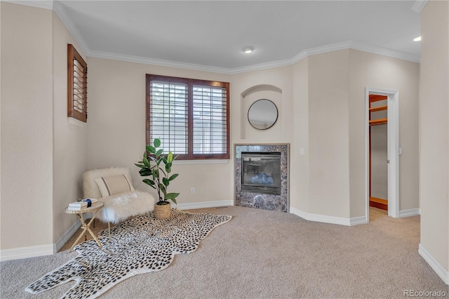 sitting room featuring crown molding, baseboards, carpet floors, and a fireplace