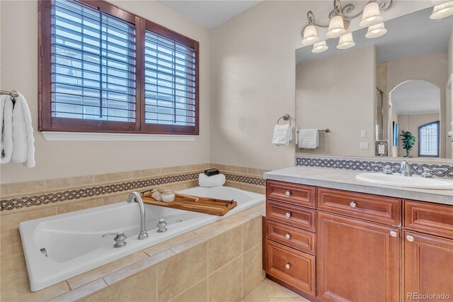 full bathroom featuring vanity, tile patterned flooring, a bath, and a chandelier