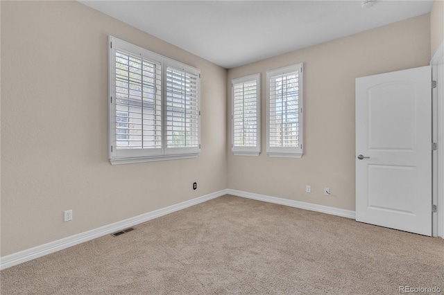 empty room with baseboards, carpet flooring, and visible vents