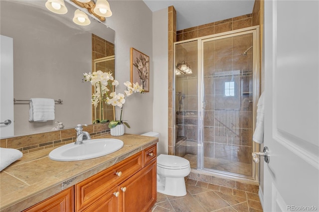 full bath featuring toilet, a shower stall, and vanity