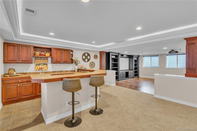 kitchen featuring visible vents, light countertops, a kitchen breakfast bar, and recessed lighting