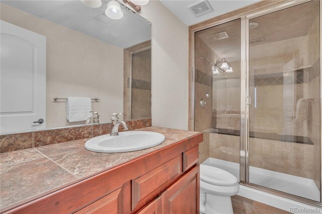 full bath with visible vents, vanity, toilet, and a shower stall