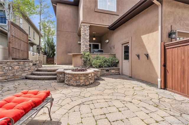 view of patio / terrace with fence and an outdoor fire pit