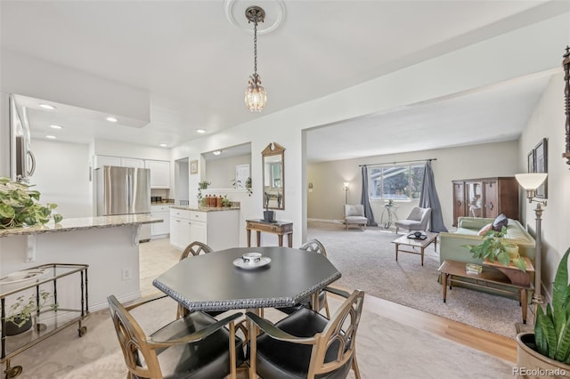 dining space featuring light carpet and recessed lighting