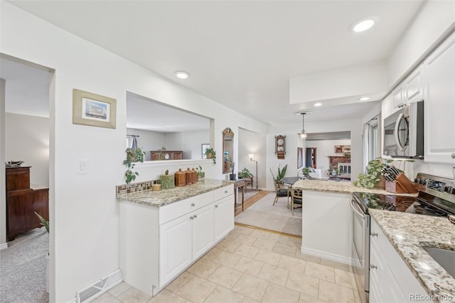kitchen featuring a peninsula, white cabinets, visible vents, recessed lighting, and appliances with stainless steel finishes