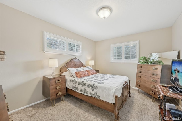 bedroom featuring baseboards and light carpet