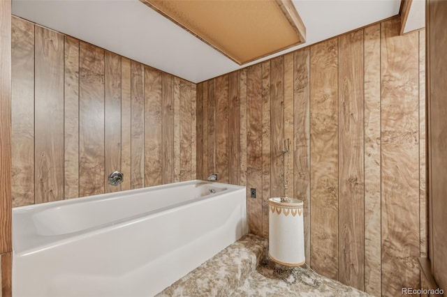 full bathroom featuring wood walls and a bath
