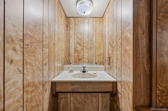 bathroom with wood walls and vanity