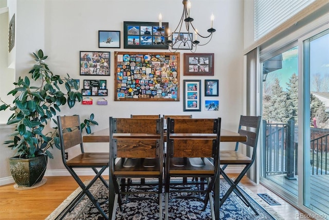 dining space with wood-type flooring and a chandelier