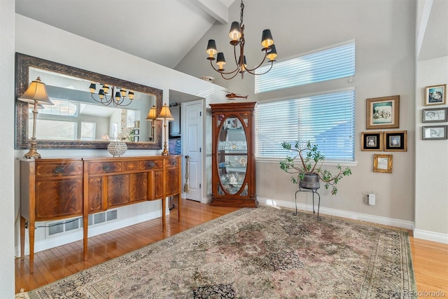 interior space with high vaulted ceiling, beam ceiling, light wood-type flooring, and a notable chandelier