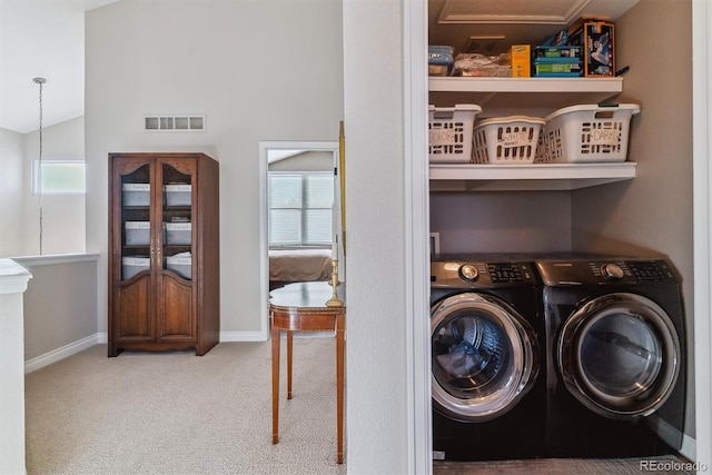 clothes washing area with washing machine and clothes dryer and carpet