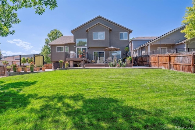 back of property with a wooden deck and a lawn