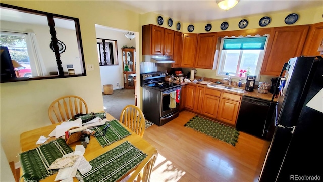 kitchen with sink, black appliances, and light wood-type flooring