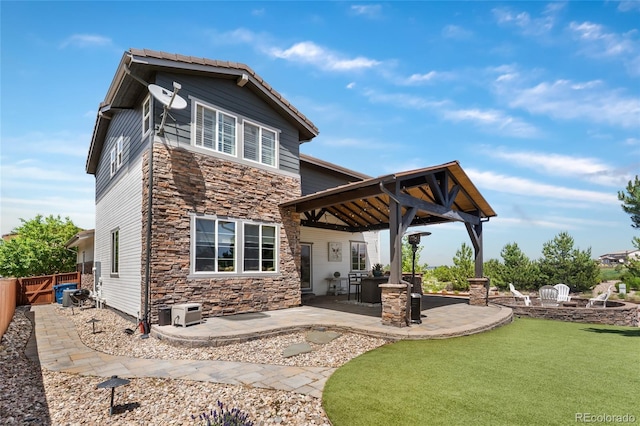 14110 Pastel Ln, Parker, CO 80134 - back of house featuring stone siding, a patio area, a fenced backyard, and a gazebo