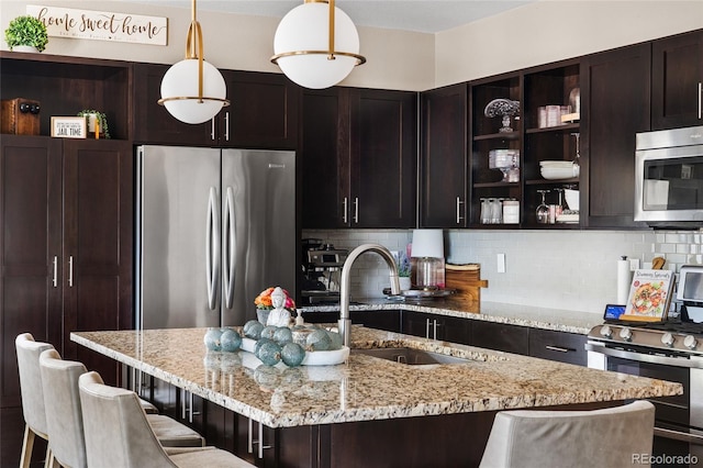 14110 Pastel Ln, Parker, CO 80134 - kitchen featuring appliances with stainless steel finishes, open shelves, backsplash, light stone counters, and pendant lighting