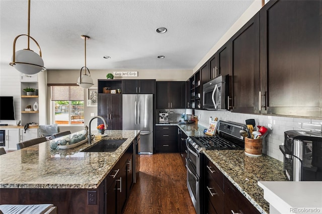 14110 Pastel Ln, Parker, CO 80134 - kitchen featuring appliances with stainless steel finishes, dark wood-style flooring, decorative backsplash, light stone countertops, and a textured ceiling