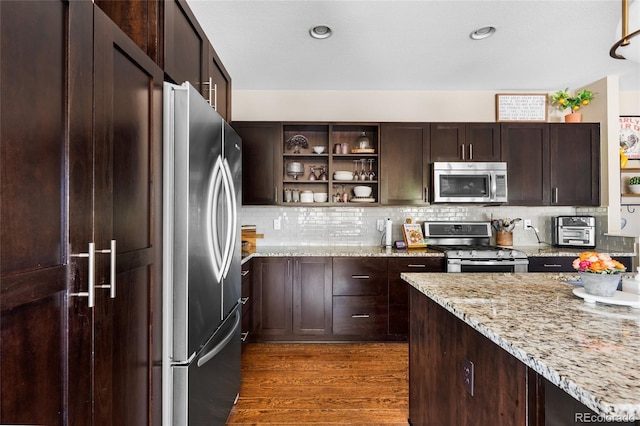 14110 Pastel Ln, Parker, CO 80134 - kitchen featuring appliances with stainless steel finishes, open shelves, dark wood-style flooring, dark brown cabinets, and tasteful backsplash
