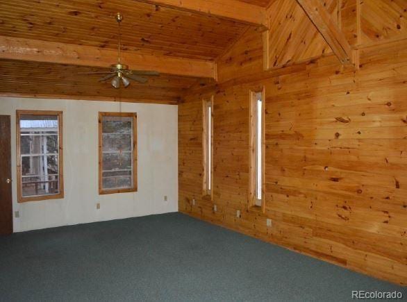 unfurnished room with carpet, ceiling fan, wooden ceiling, beamed ceiling, and wood walls