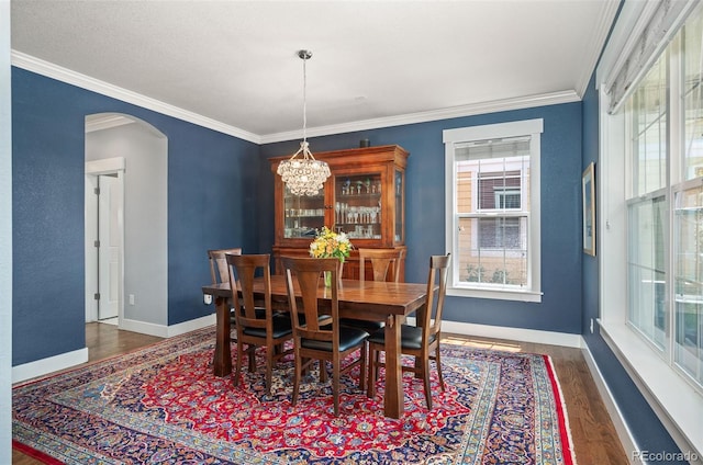 2746 Geneva St, Denver, CO 80238 - dining area featuring arched walkways, wood finished floors, ornamental molding, and a chandelier