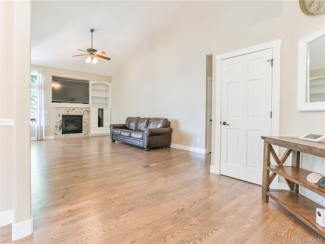 19249 E Progress Ave, Centennial, CO 80015 - living room featuring ceiling fan, light wood-style flooring, a glass covered fireplace, lofted ceiling, and built in features