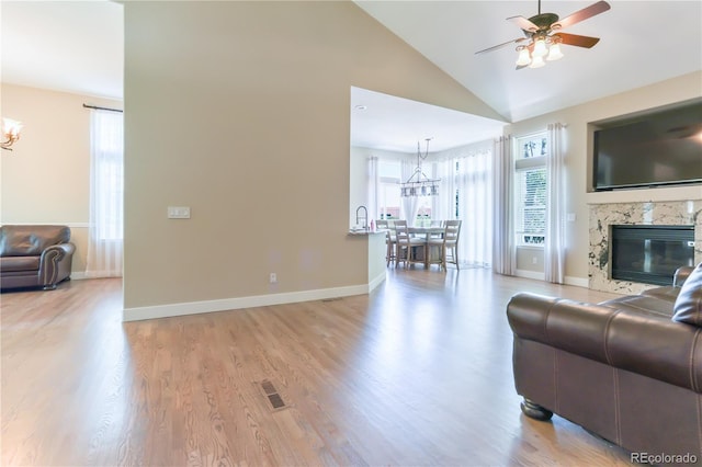 19249 E Progress Ave, Centennial, CO 80015 - living area featuring a chandelier, a ceiling fan, light wood-style flooring, a premium fireplace, and high vaulted ceiling
