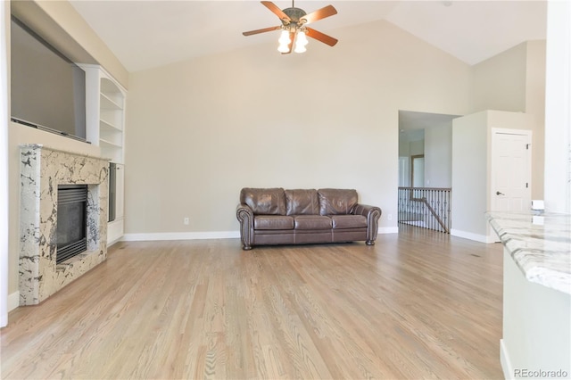 19249 E Progress Ave, Centennial, CO 80015 - living area with a ceiling fan, light wood-style flooring, high vaulted ceiling, a premium fireplace, and built in shelves