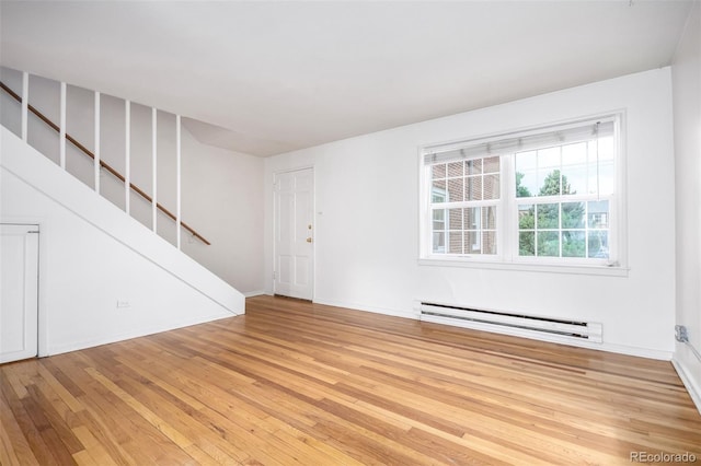 2856 Jasmine St, Denver, CO 80207 - unfurnished room featuring a baseboard heating unit, light wood-style floors, stairway, and baseboards