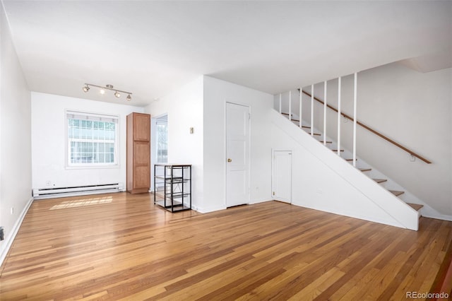 2856 Jasmine St, Denver, CO 80207 - unfurnished living room with a baseboard heating unit, stairs, light wood-style flooring, and baseboards