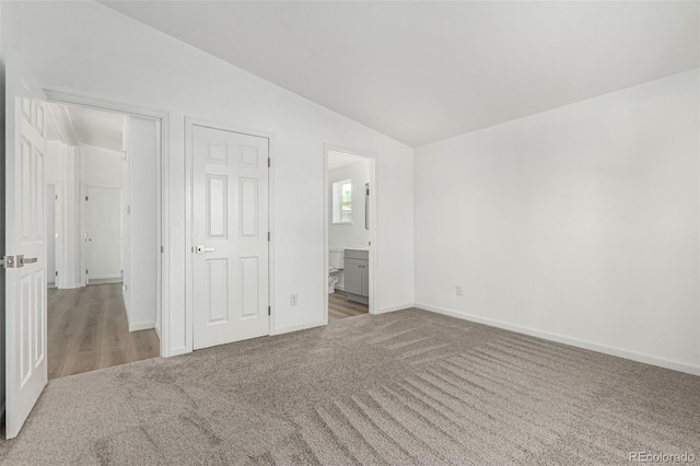 657 Locust Ave, Lochbuie, CO 80603 - unfurnished bedroom featuring carpet, lofted ceiling, and ensuite bathroom