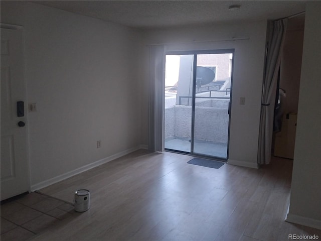 empty room with wood-type flooring and a textured ceiling