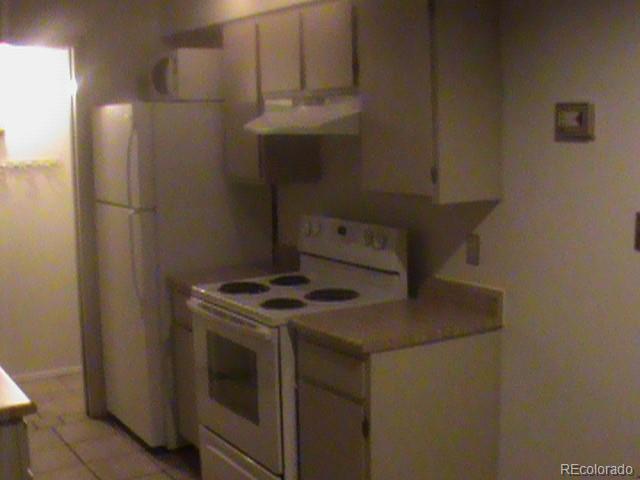 1845 N Kendall St Unit 316D, Lakewood, CO 80214 - kitchen featuring electric stove, range hood, light countertops, and white cabinetry