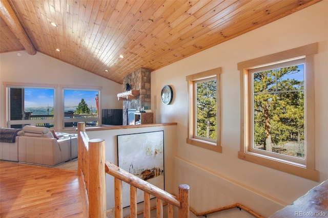 hall featuring wood ceiling, a healthy amount of sunlight, lofted ceiling with beams, and light wood-type flooring