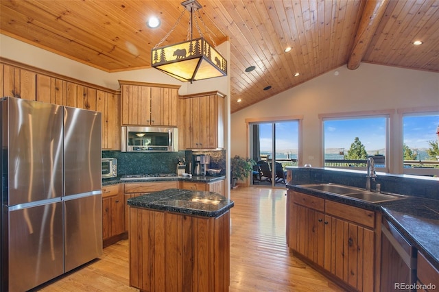 kitchen featuring decorative light fixtures, backsplash, stainless steel appliances, sink, and a kitchen island