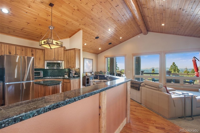 kitchen with appliances with stainless steel finishes, sink, tasteful backsplash, beam ceiling, and pendant lighting