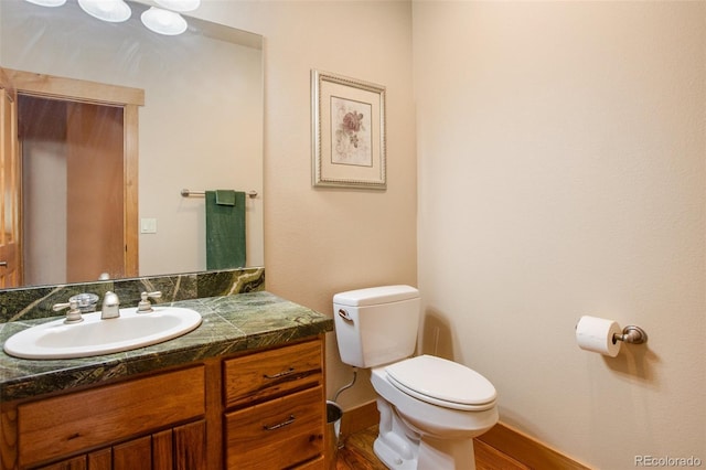 bathroom with toilet, large vanity, and hardwood / wood-style flooring