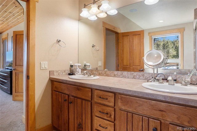 bathroom featuring lofted ceiling and dual bowl vanity