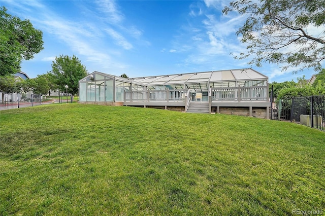 back of house with a wooden deck and a lawn