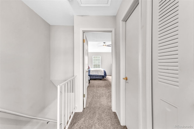 corridor featuring an upstairs landing and carpet
