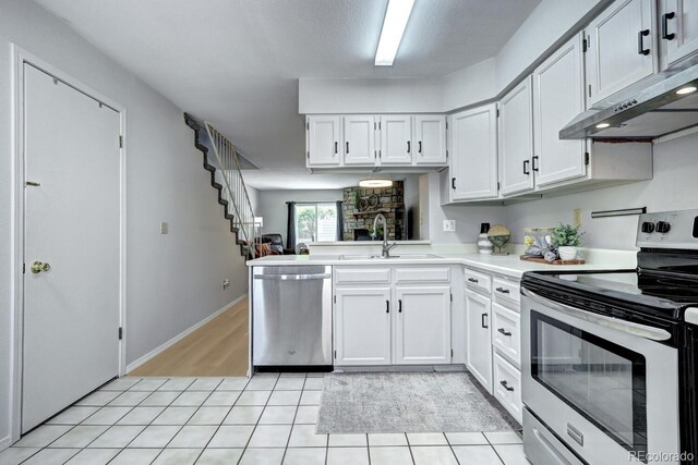 19804 Summerset Ln, Parker, CO 80138 - kitchen featuring stainless steel appliances, under cabinet range hood, light tile patterned floors, light countertops, and white cabinetry